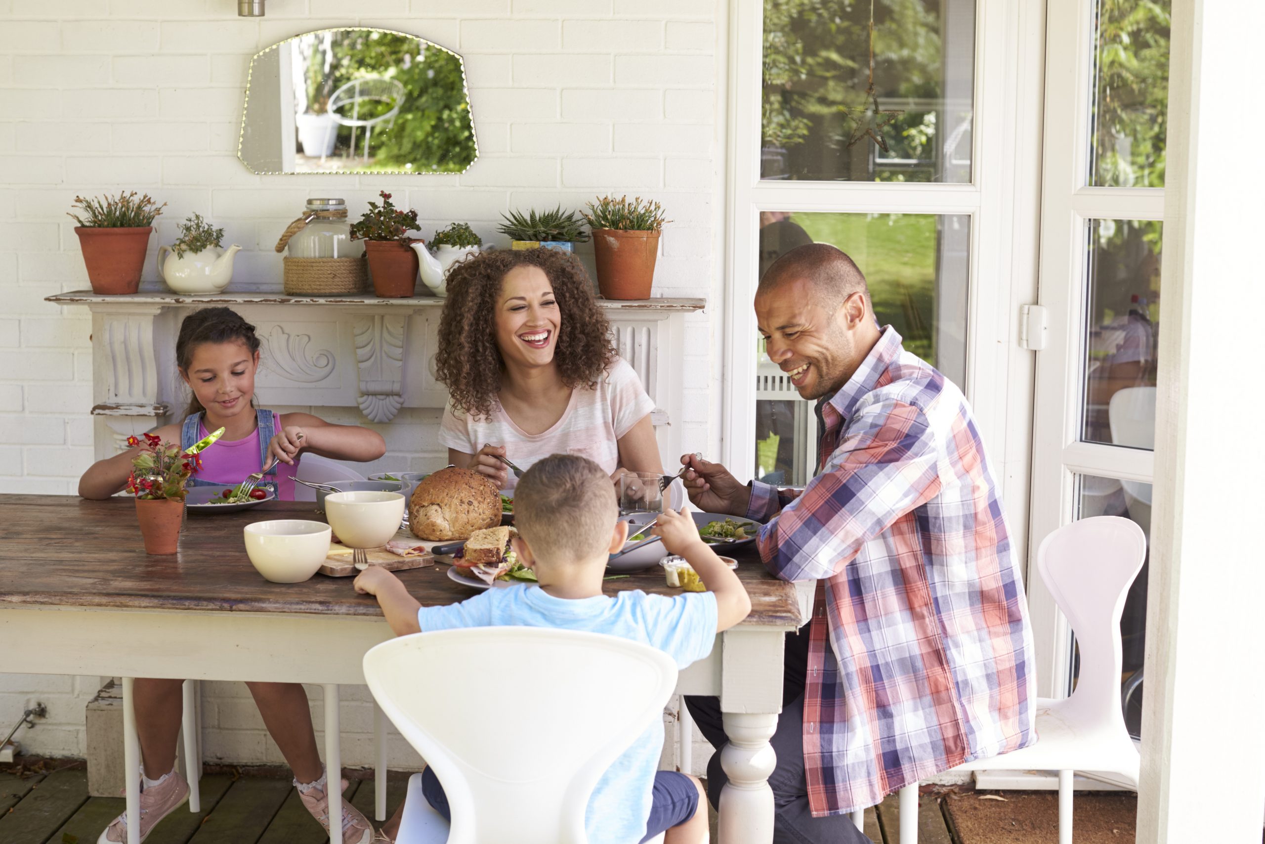 Family At Home Eating Outdoor Meal Together